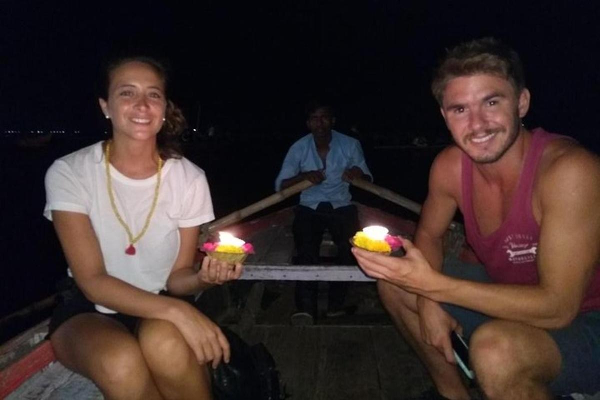 seorang lelaki dan seorang wanita memegang dua kek cawan dengan lilin yang dinyalakan