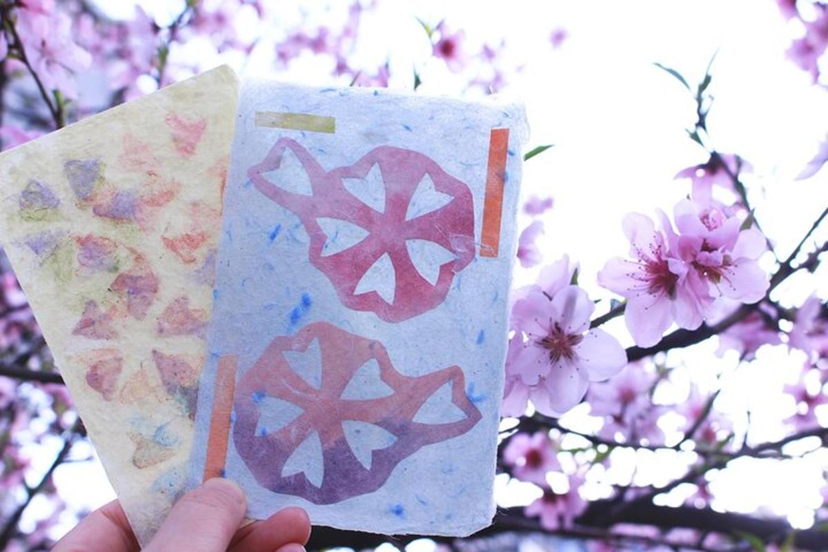 Una persona sosteniendo un trozo de papel con flores rosas.