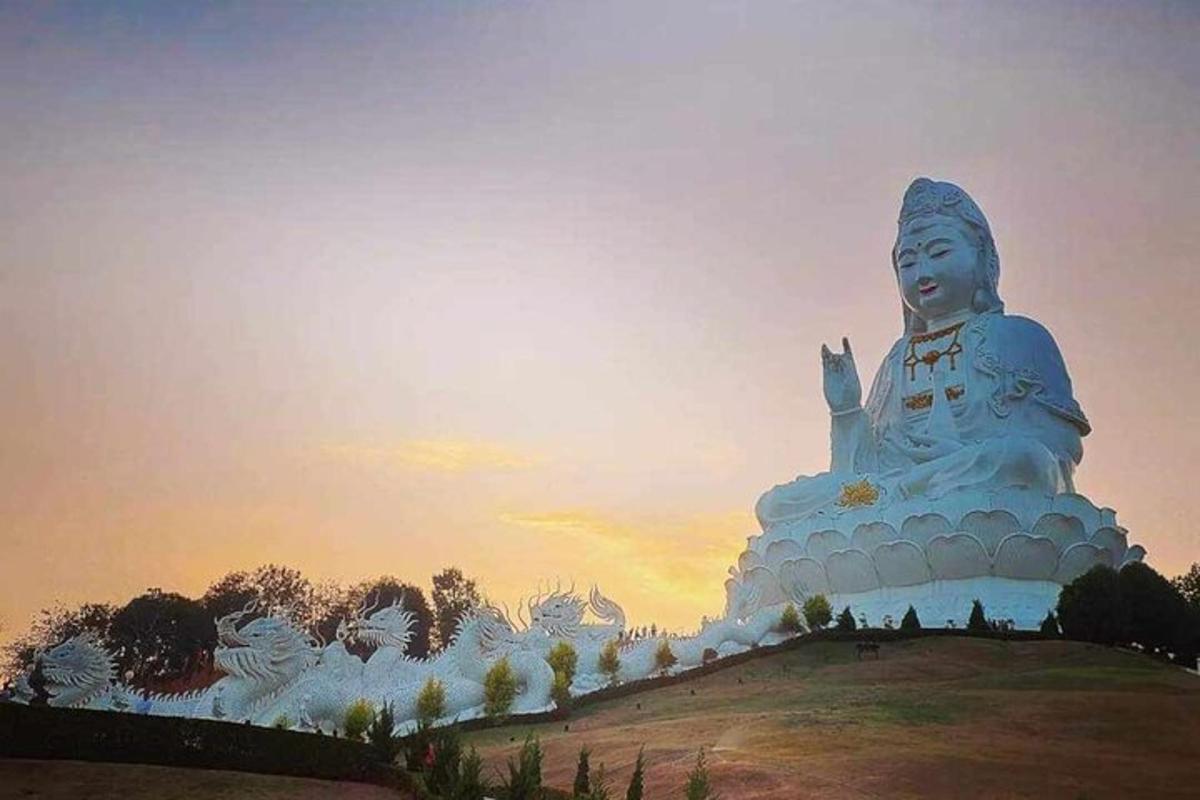 một bức tượng lớn màu trắng ngồi trên đỉnh đồi