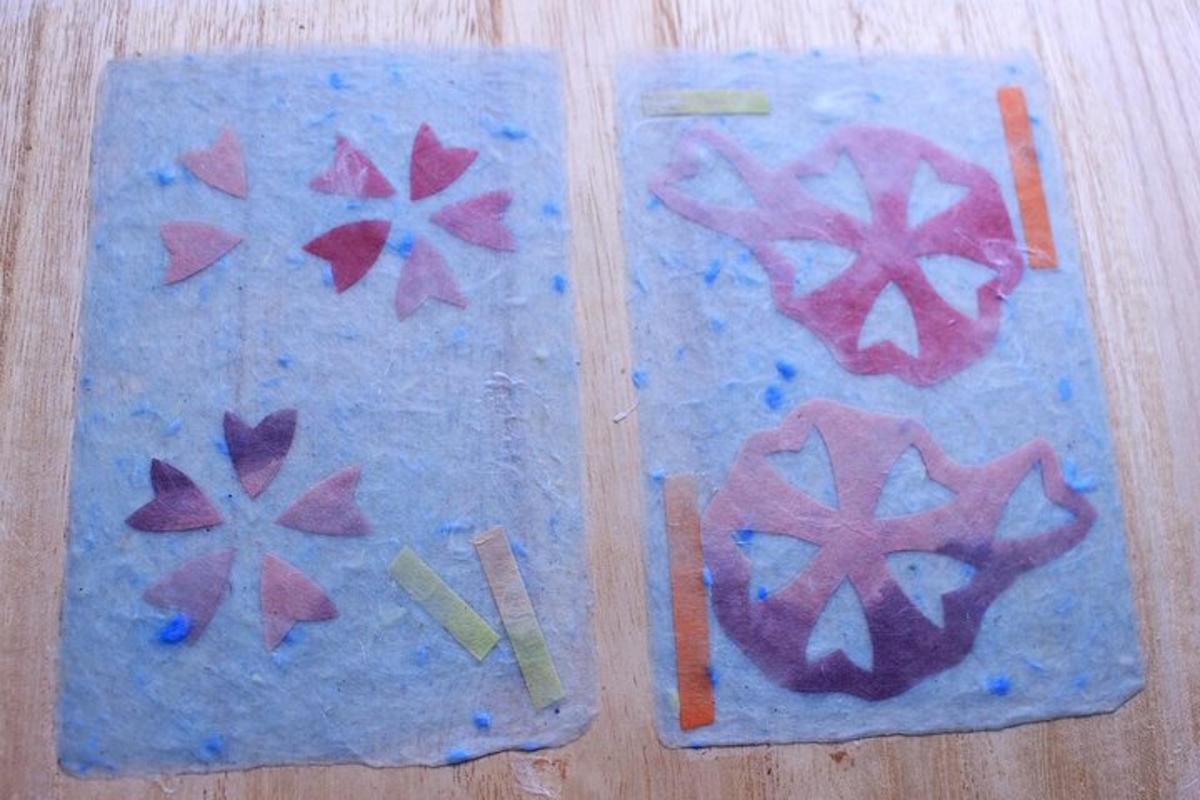 Dos tablas de cortar con pinturas de flores en ellas.