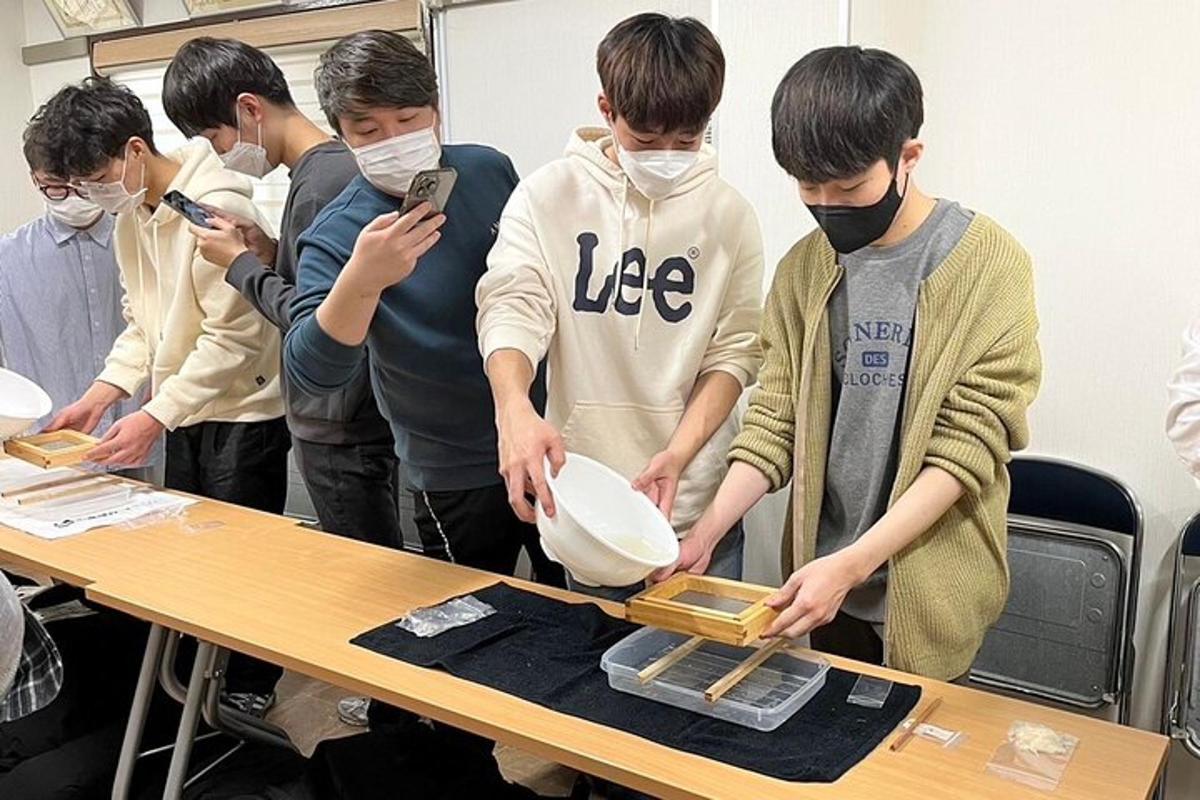 Un grupo de jóvenes de pie alrededor de una mesa con un cuenco.