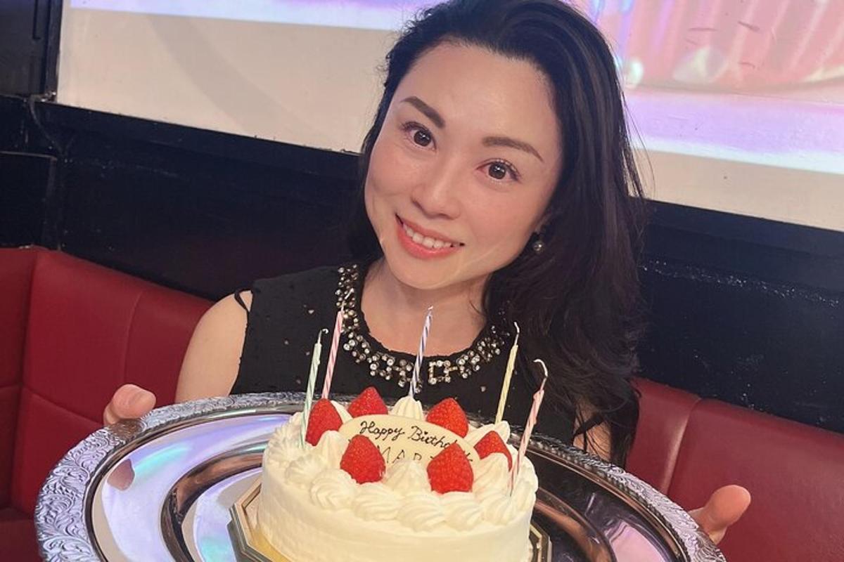 a woman holding a cake with strawberries on it