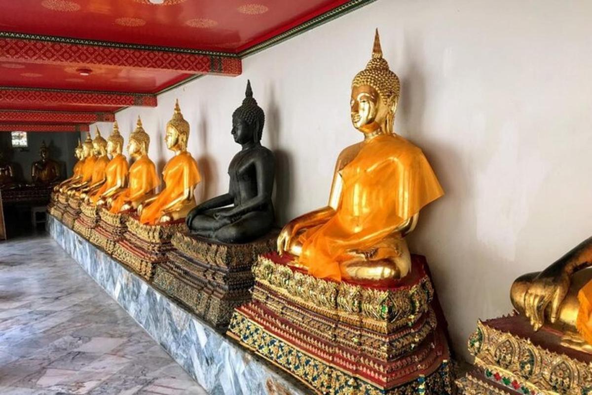 uma fileira de estátuas douradas de Buda em uma sala