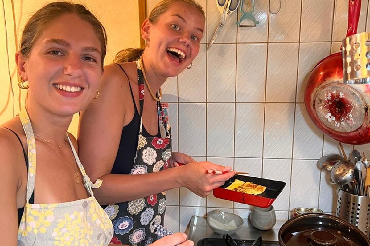 deux femmes debout dans une cuisine tenant une assiette de nourriture