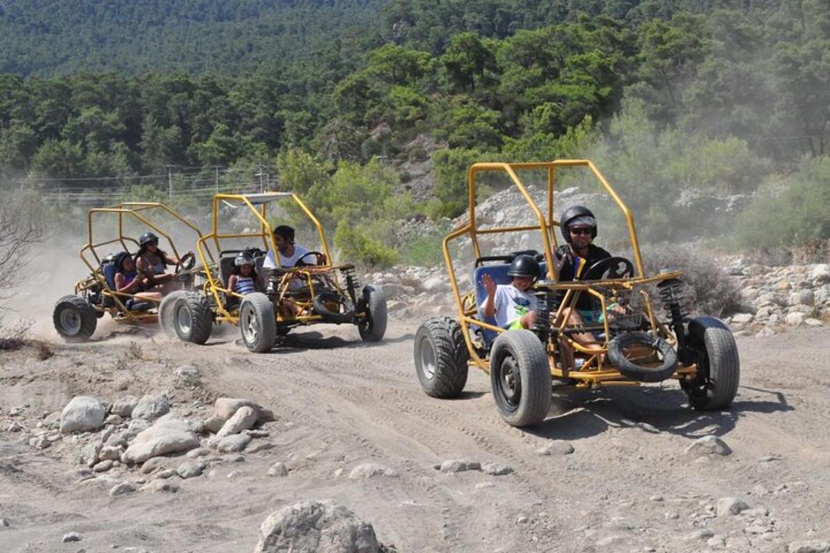 Tres personas viajando en vehículos de cuatro ruedas por un camino de tierra