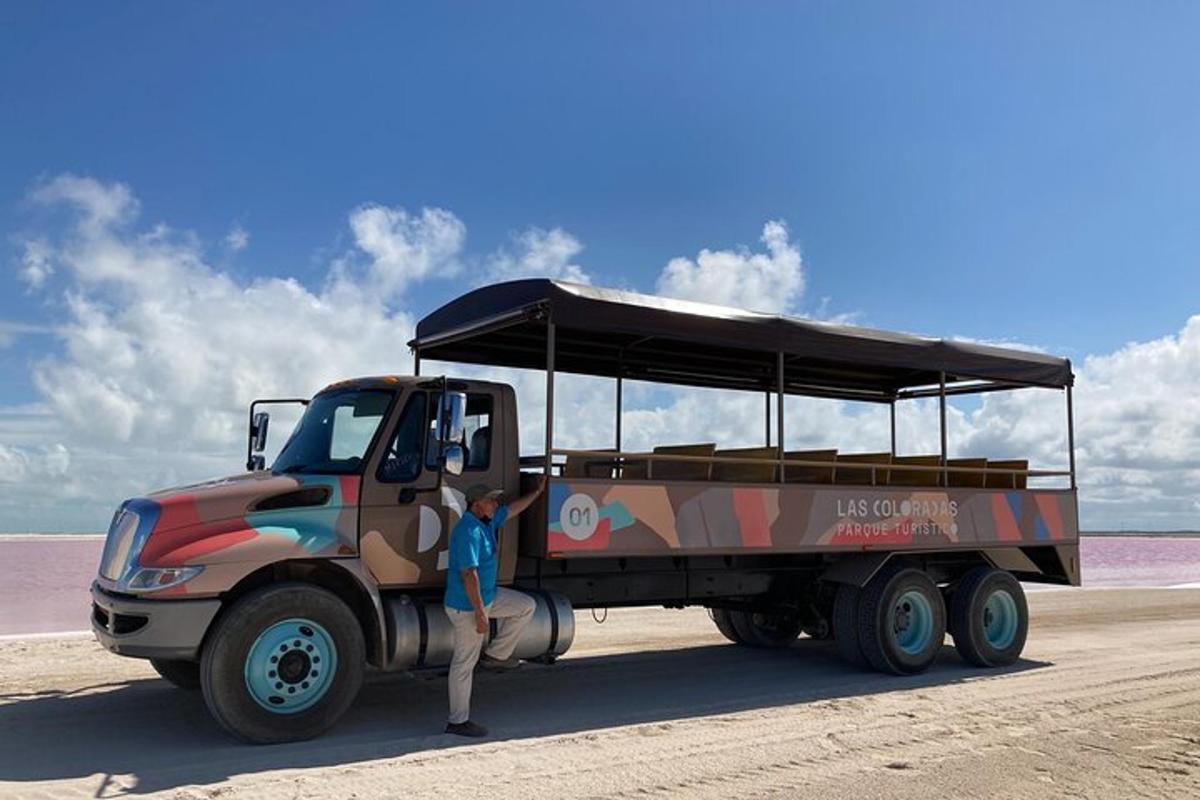 a person standing next to a camo truck on the beach