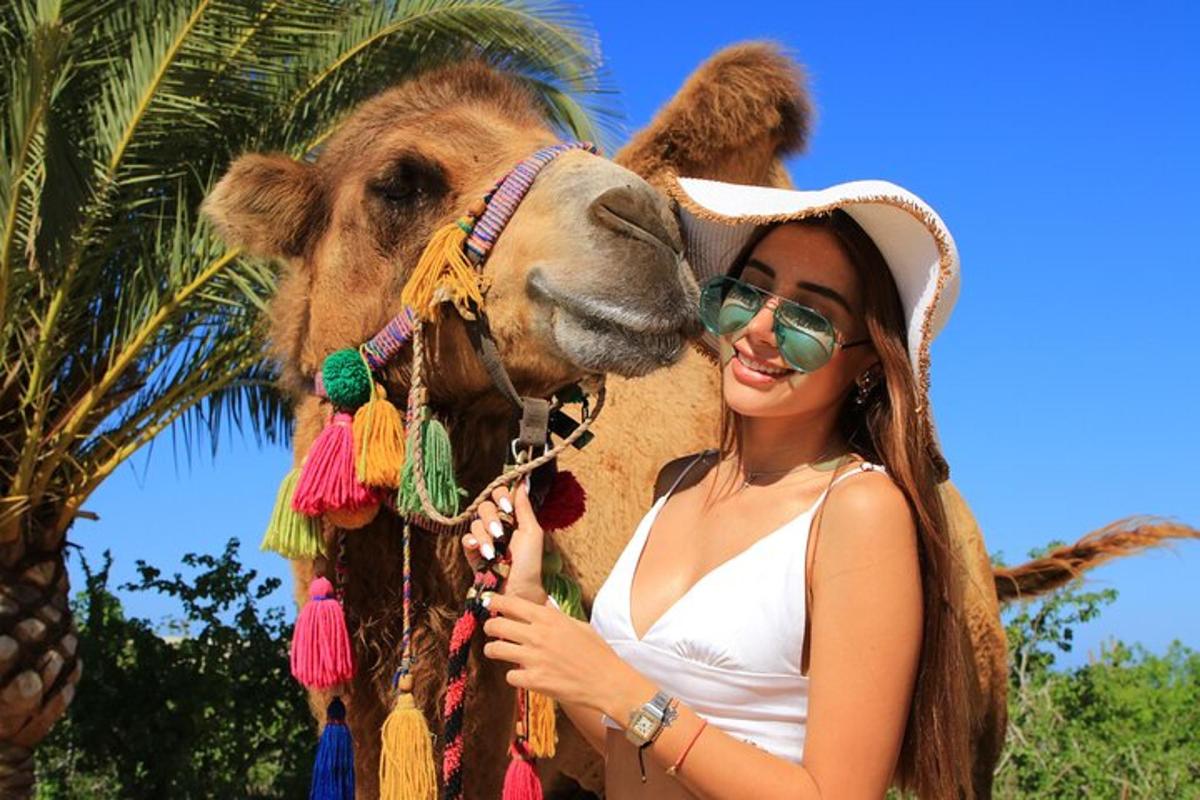 a woman standing next to a camel