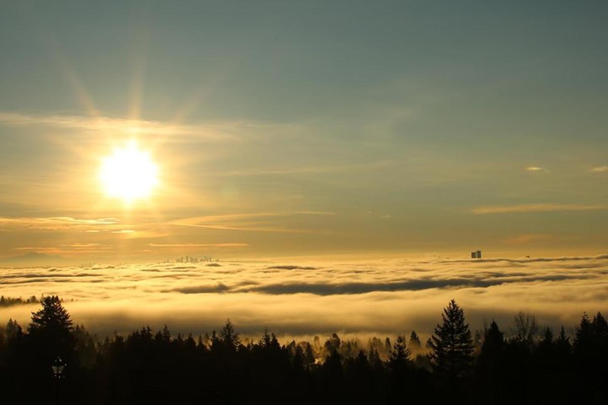 pogled na sonce, ki vzhaja nad morjem oblakov