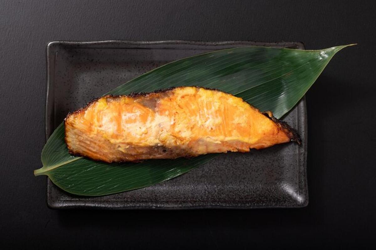 a piece of fish on top of a green leaf