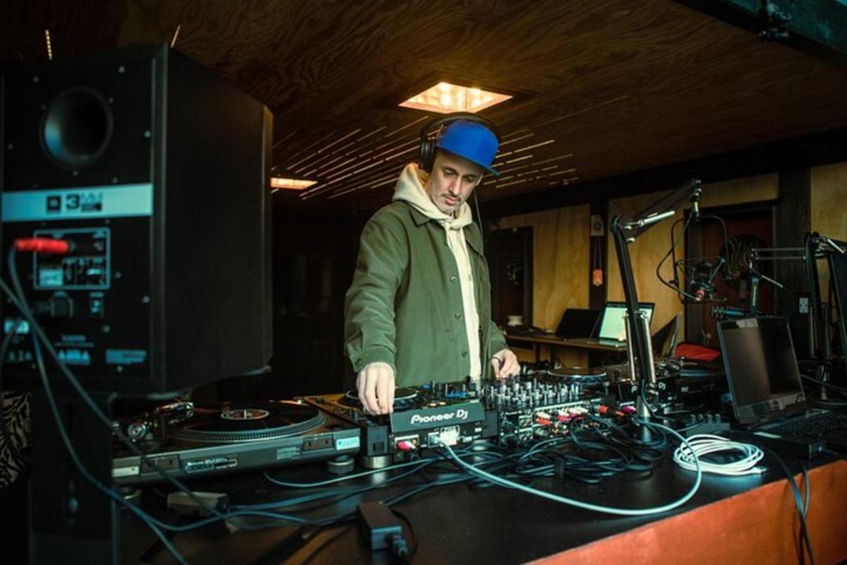 muž stojící za mixážním pultem v nahrávacím studiu