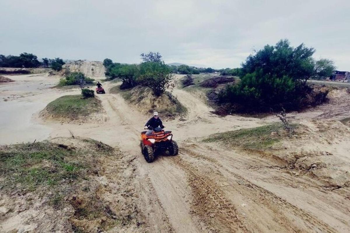 žmogus, važiuojantis keturračiu žvyrkeliu