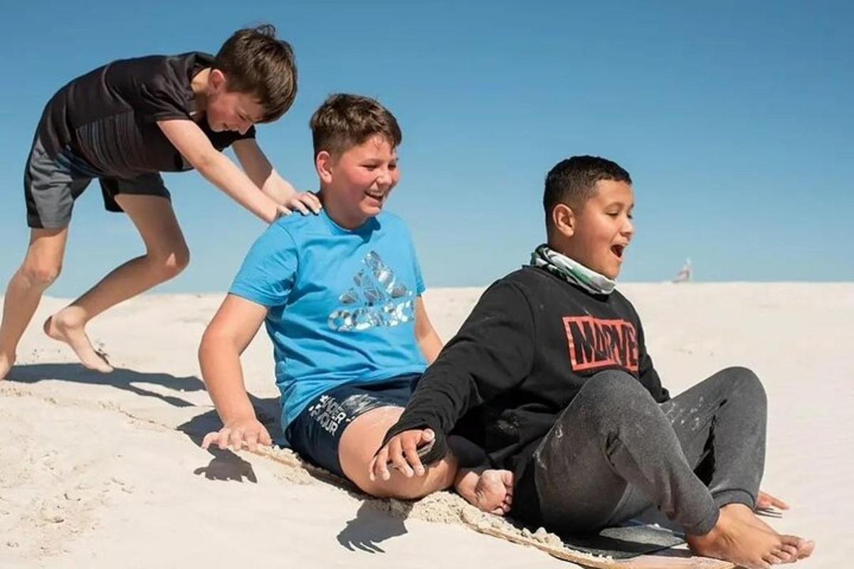to gutter som sitter i sanden på stranden