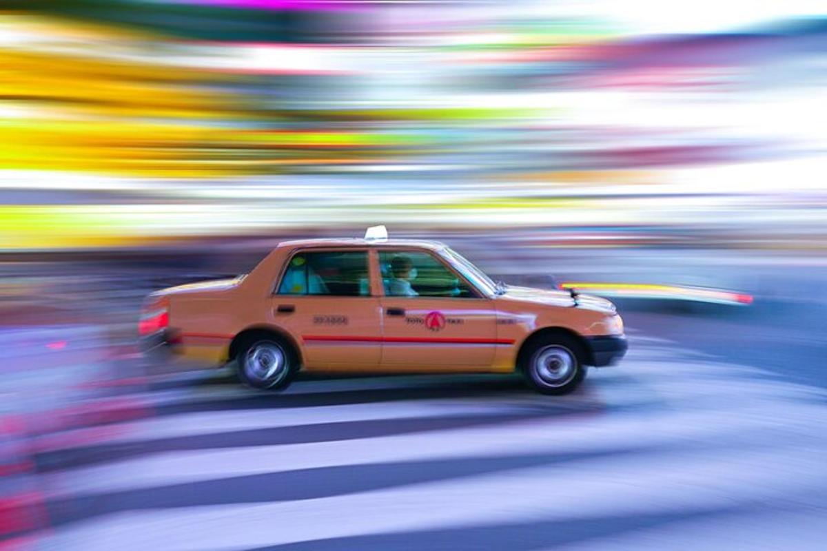 an orange car is driving down the street