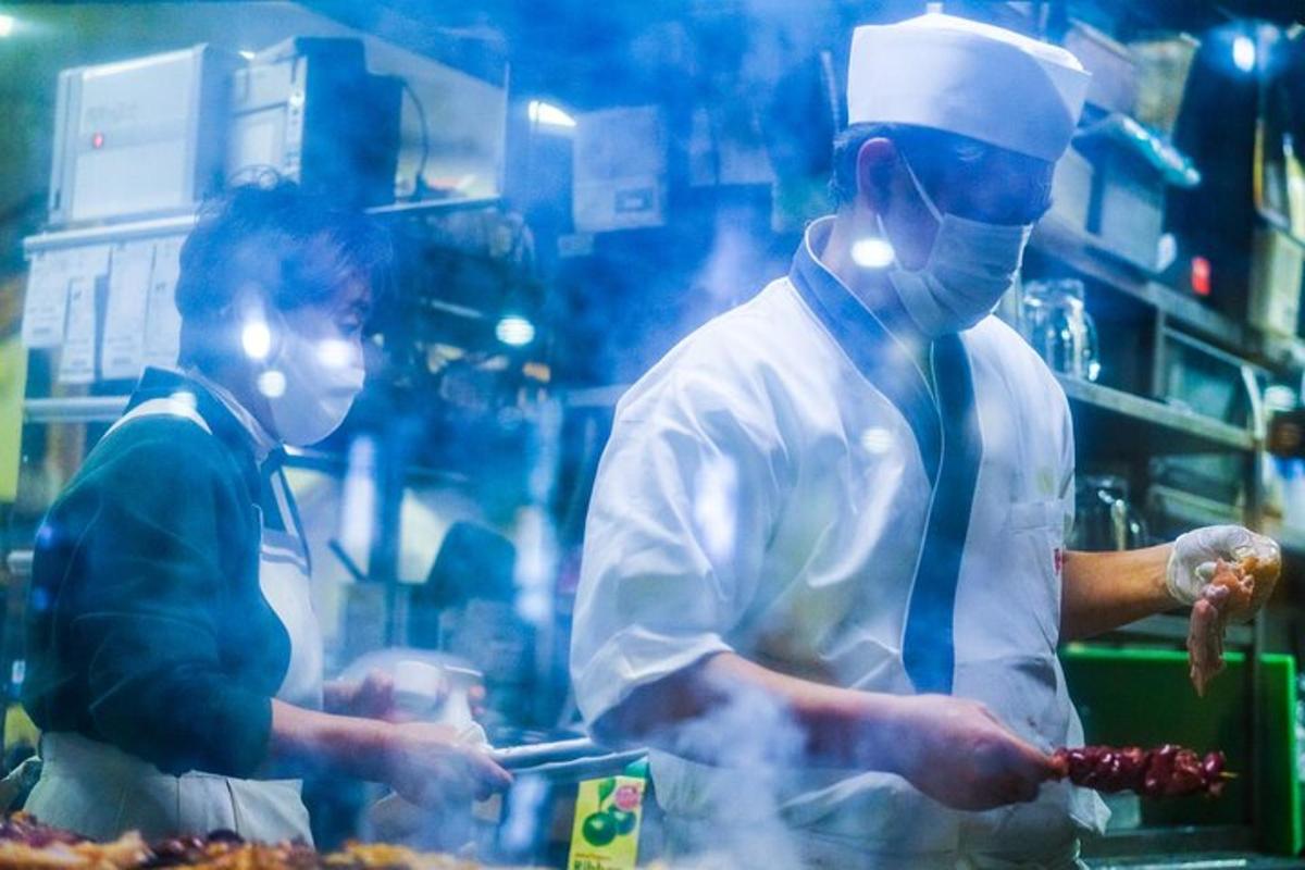 two chefs standing in a kitchen preparing food