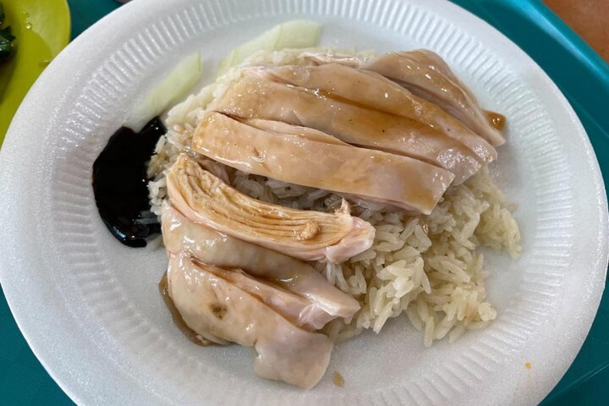 ein Teller mit Hühnchen und Reis auf einem Tisch