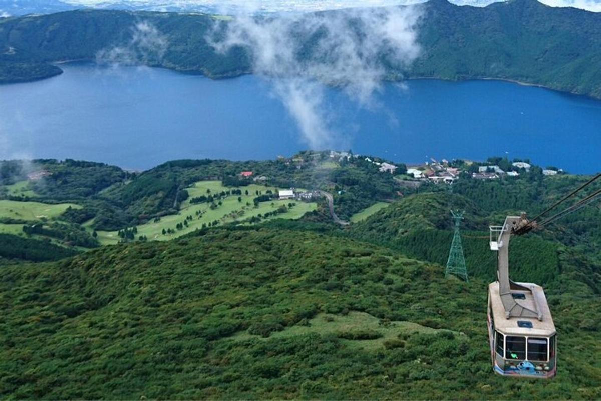 una góndola volant sobre un turó verd amb un llac