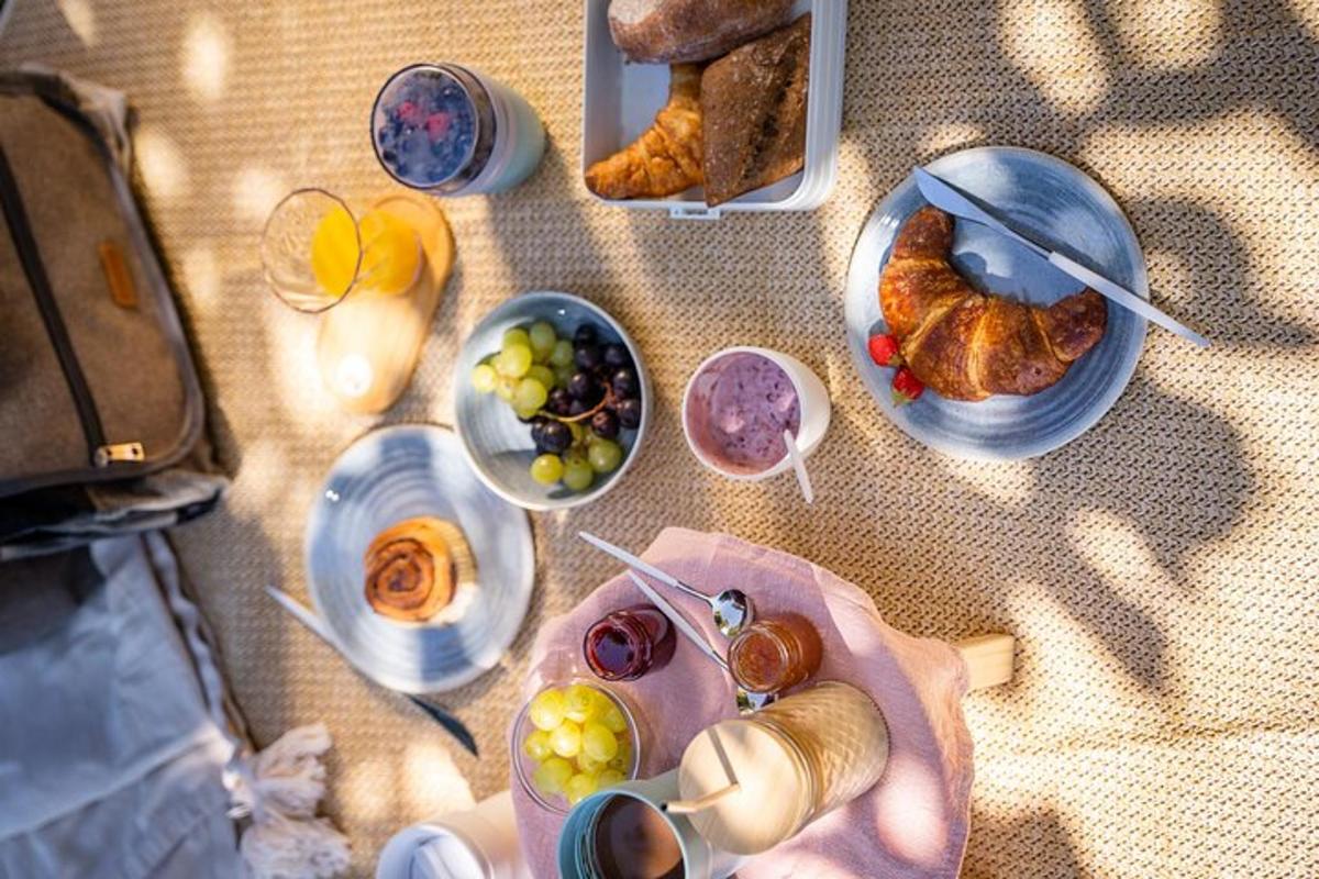 ein Tisch mit Tellern voller Essen und Schalen mit Obst