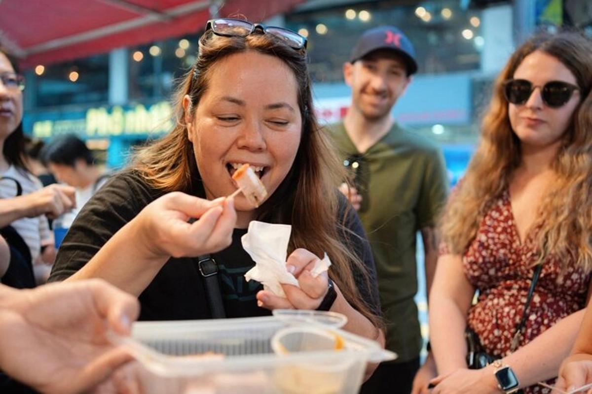 a woman eating food in a group of people