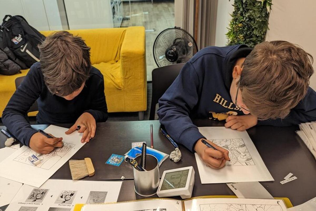 duas mulheres sentadas à mesa trabalhando em desenhos