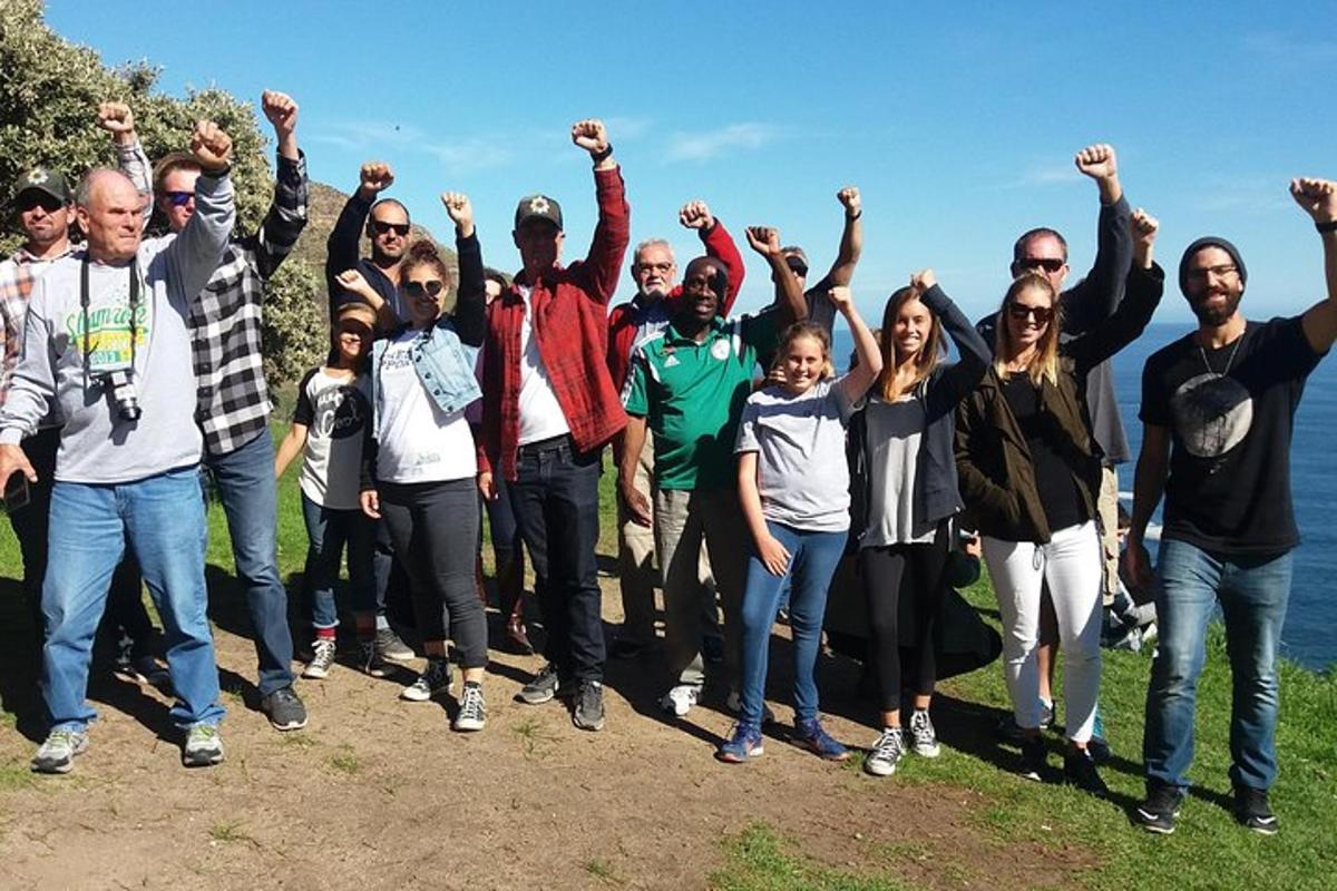 un gruppo di persone in piedi su una collina con le mani alzate