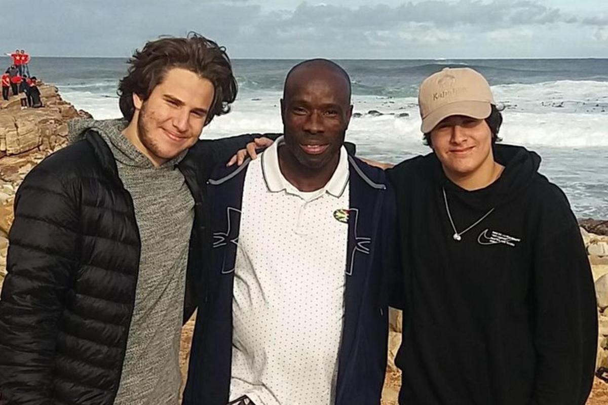 tre uomini posano per una foto in spiaggia