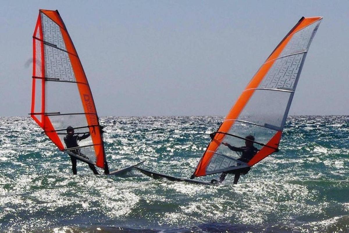 Dva lidé windsurfují v oceánu