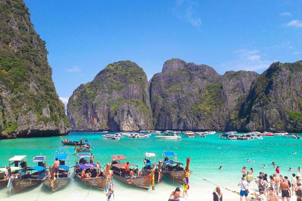 กลุ่มเรือบนชายหาดพร้อมกับผู้คนในน้ำ
