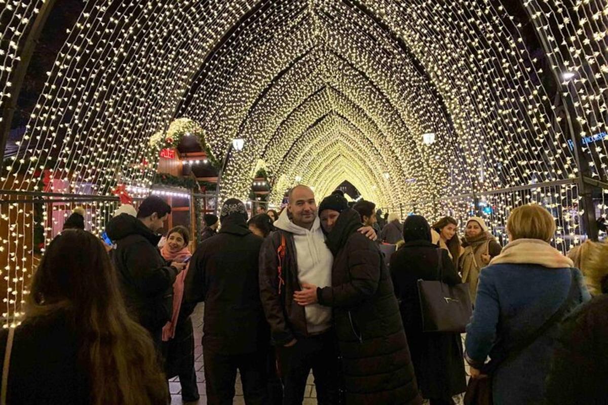 a group of people standing in a room with christmas lights
