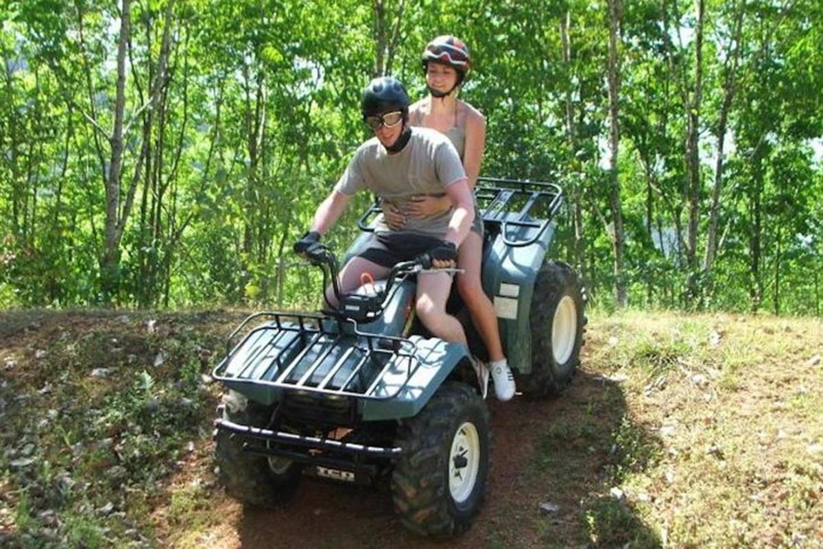 zwei Personen fahren auf einem Quad auf einem Pfad