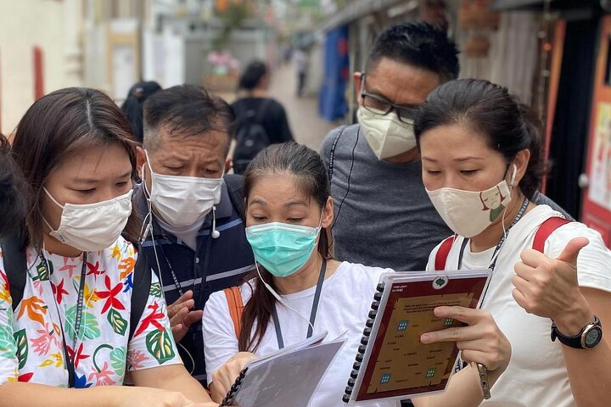 một nhóm người đeo khẩu trang đang nhìn vào máy tính xách tay
