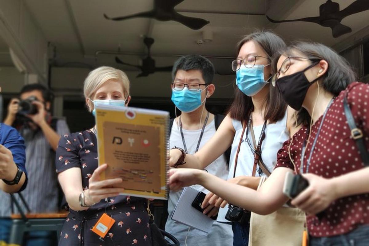 một nhóm người đeo khẩu trang đang cầm máy tính xách tay