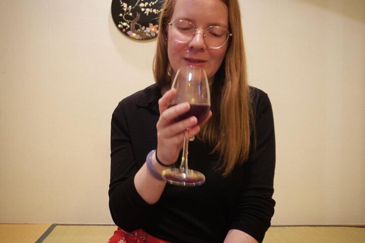 a woman holding a glass of red wine