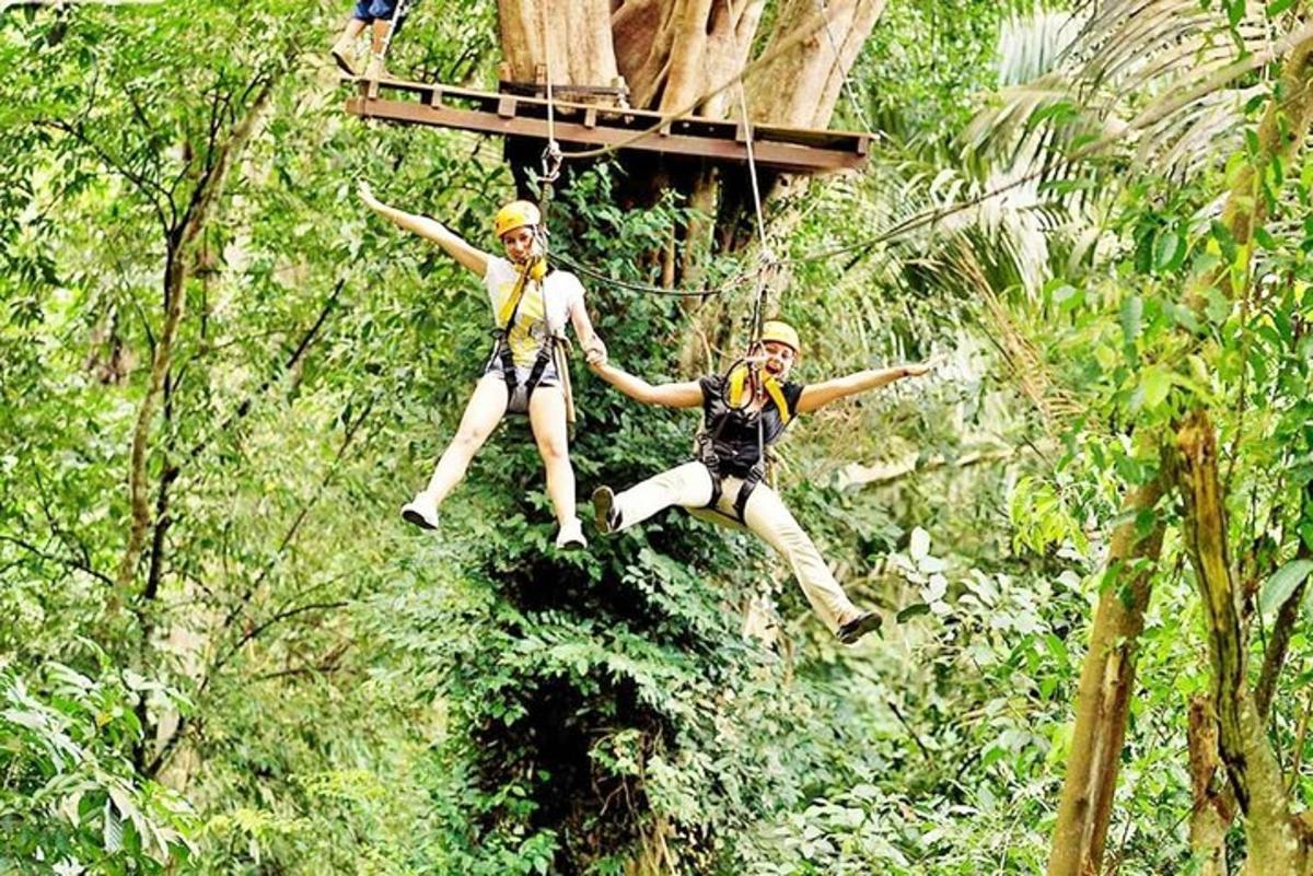 due persone che saltano da una teleferica nella giungla