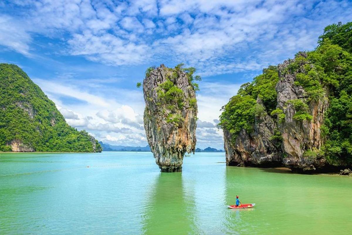 un homme dans un kayak dans l'eau avec une grande formation rocheuse