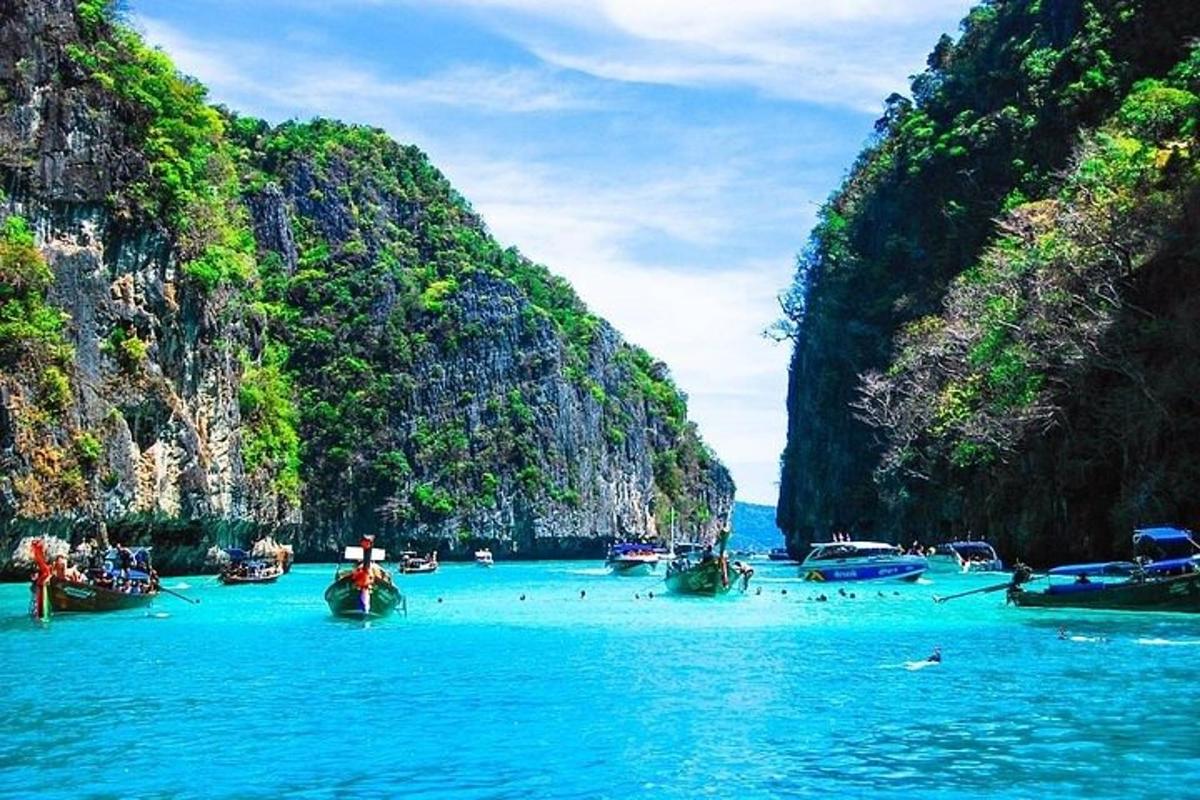 a group of boats in the water next to cliffs