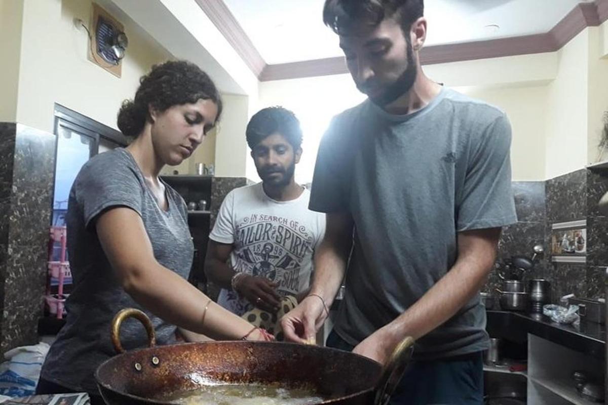 three people standing in a kitchen with a bowl