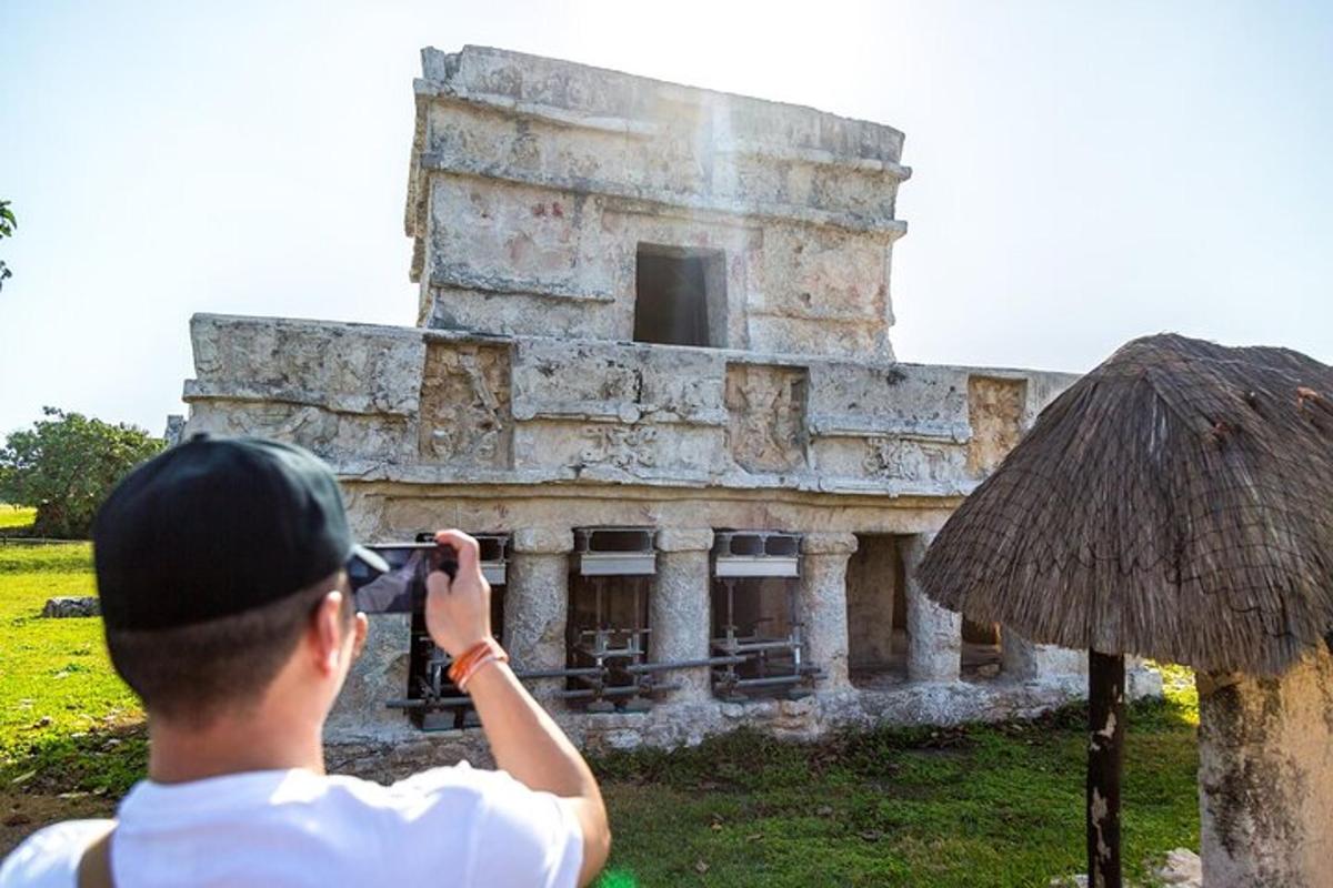 muž fotografující budovu fotoaparátem
