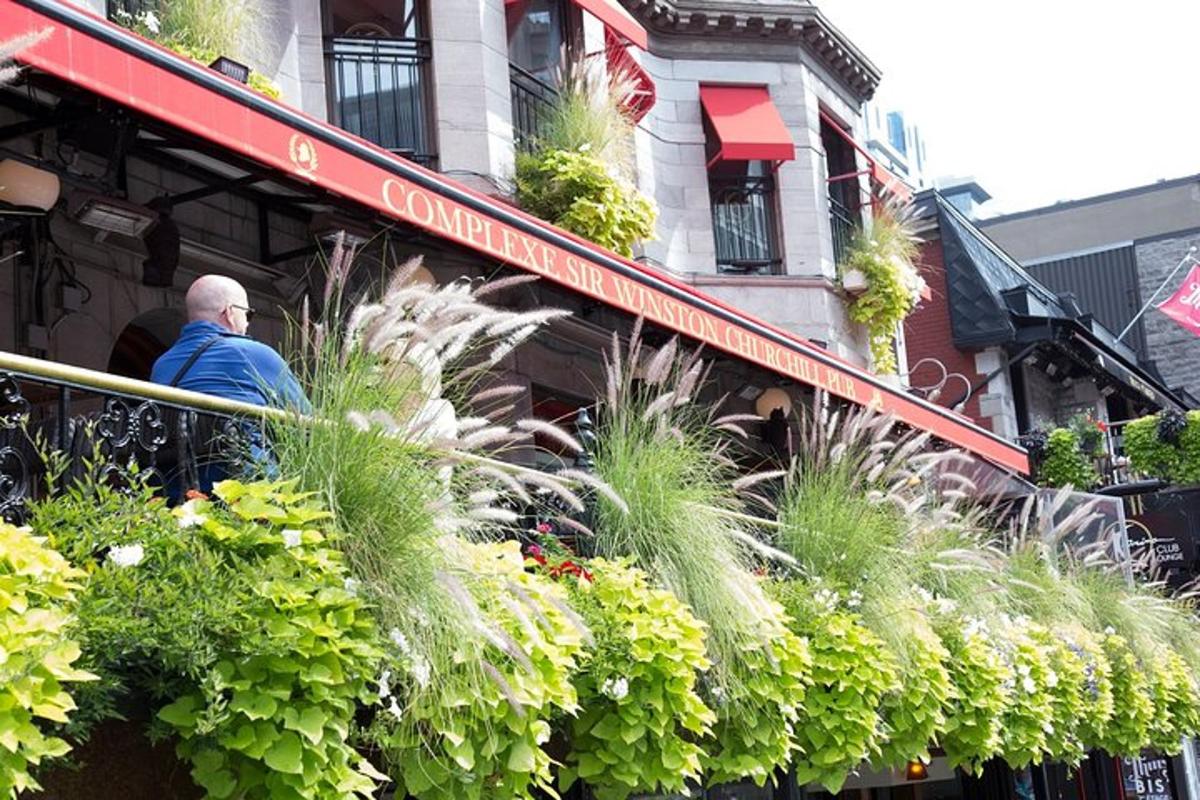 a man standing on a balcony of a building with plants