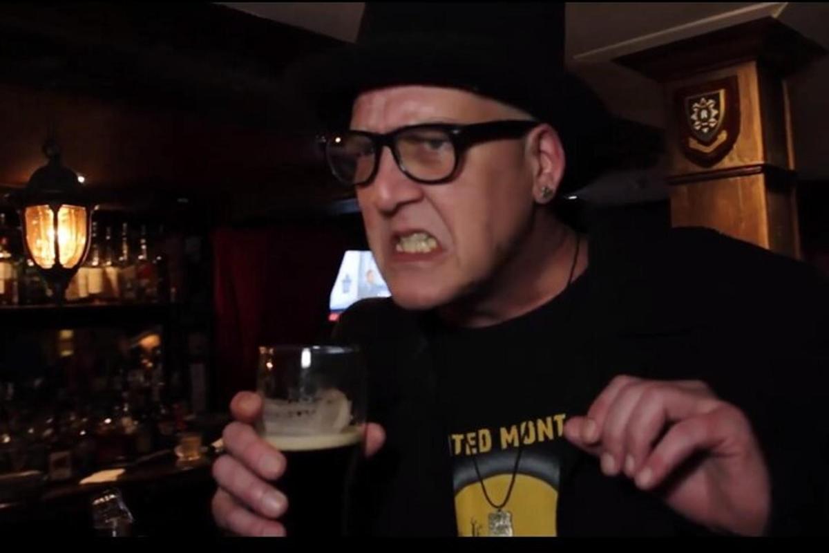 a man holding a glass of beer in a bar