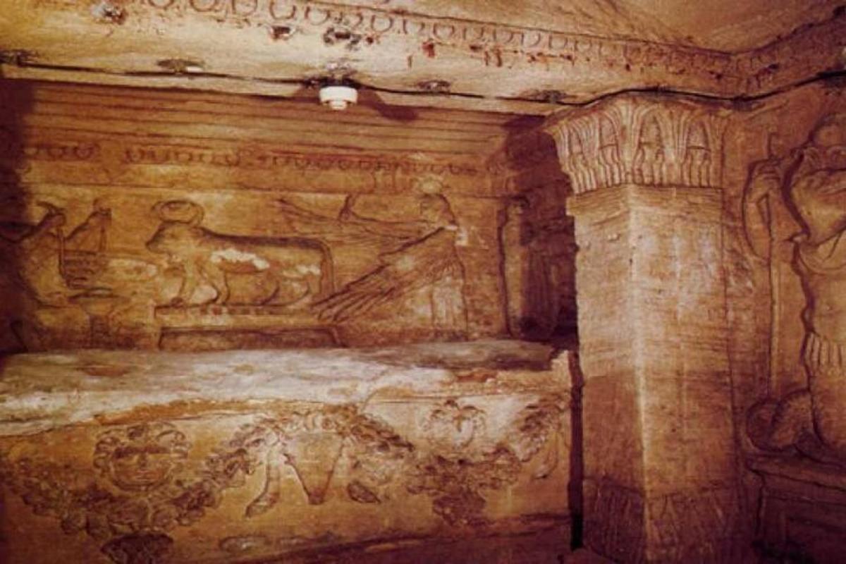 an ancient room with a bed with graffiti on it