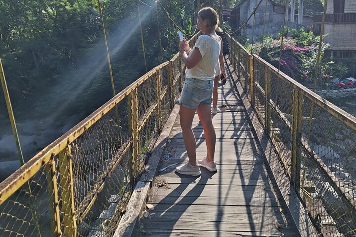 eine Frau steht auf einer Brücke und schaut auf ihr Handy