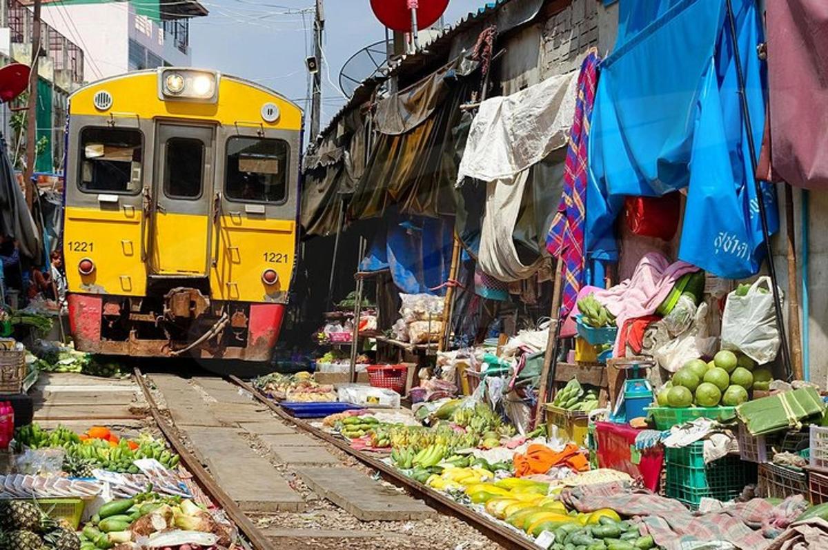 um trem passando por um mercado com frutas e vegetais