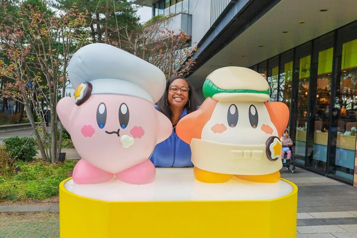 a woman is standing next to two hello kitty statues