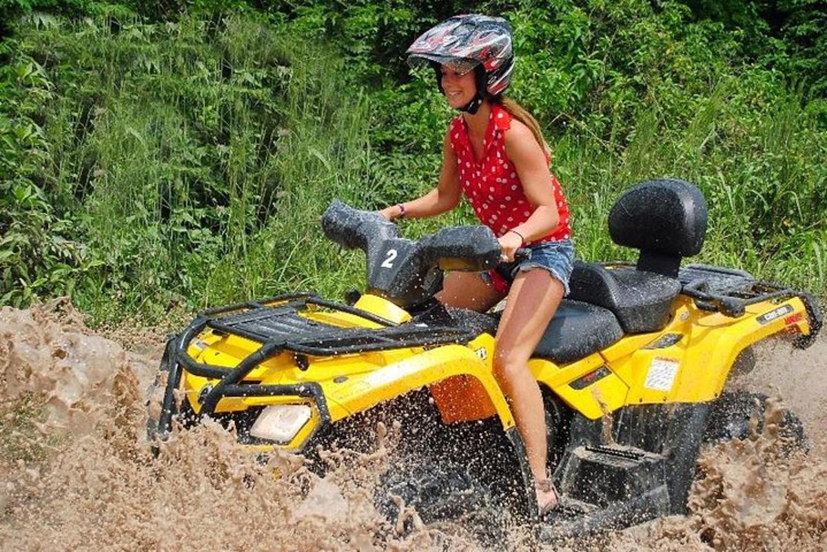 mladá dívka jedoucí na hračce na motorce v blátě