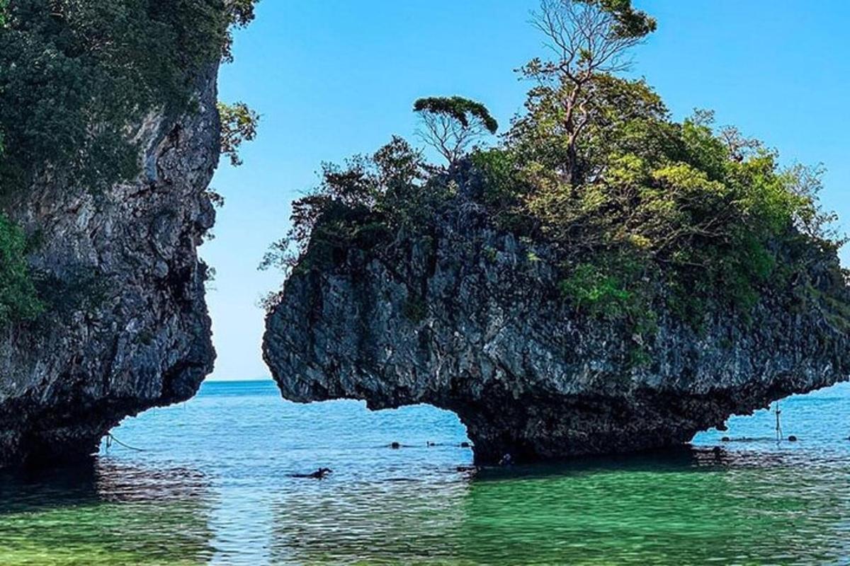 sebuah pulau di lautan dengan orang di dalam air