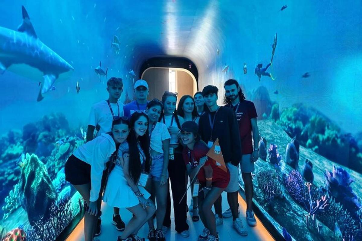 a group of people standing in front of an aquarium