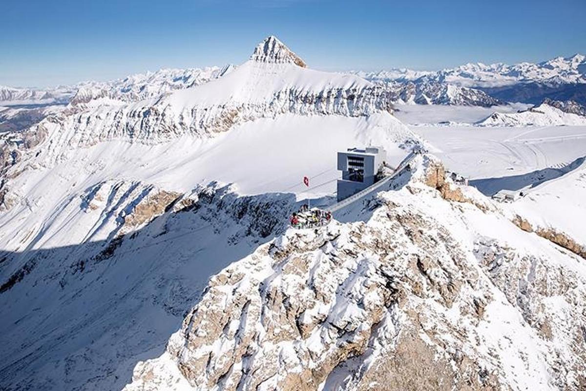 a snow covered mountain with a building on top of it