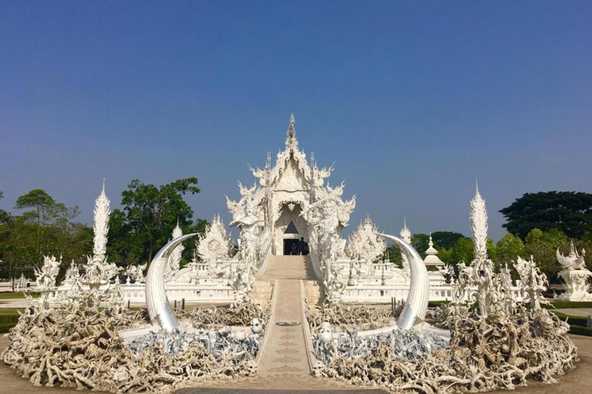 um prédio branco com uma fonte em um parque