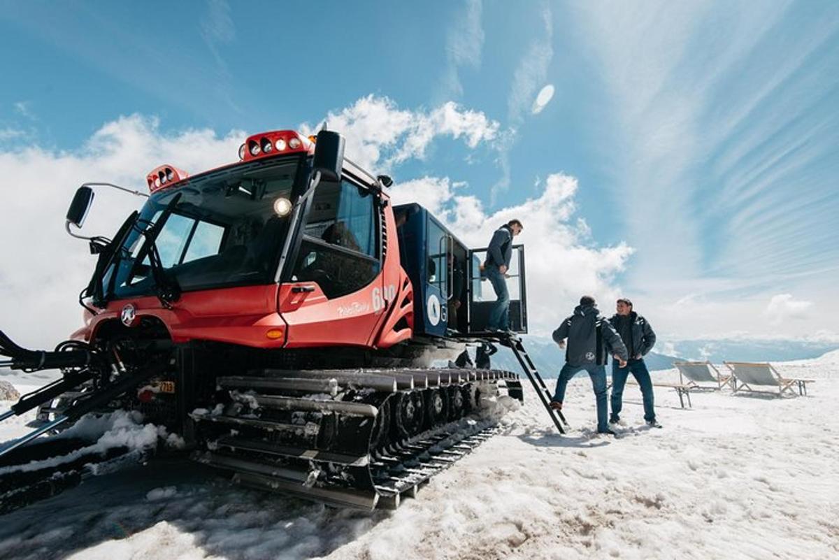 a group of people standing next to a snow truck