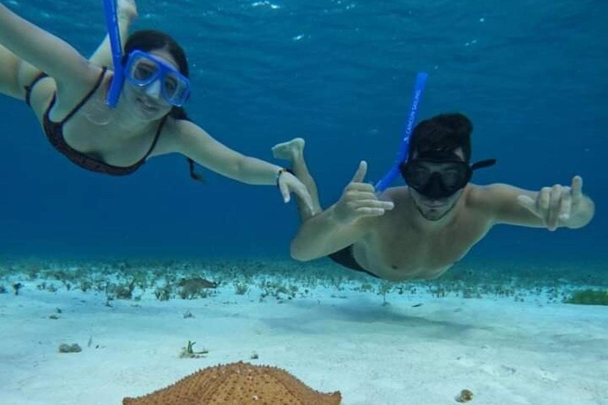 due persone in acqua che fanno il gesto del pollice in su